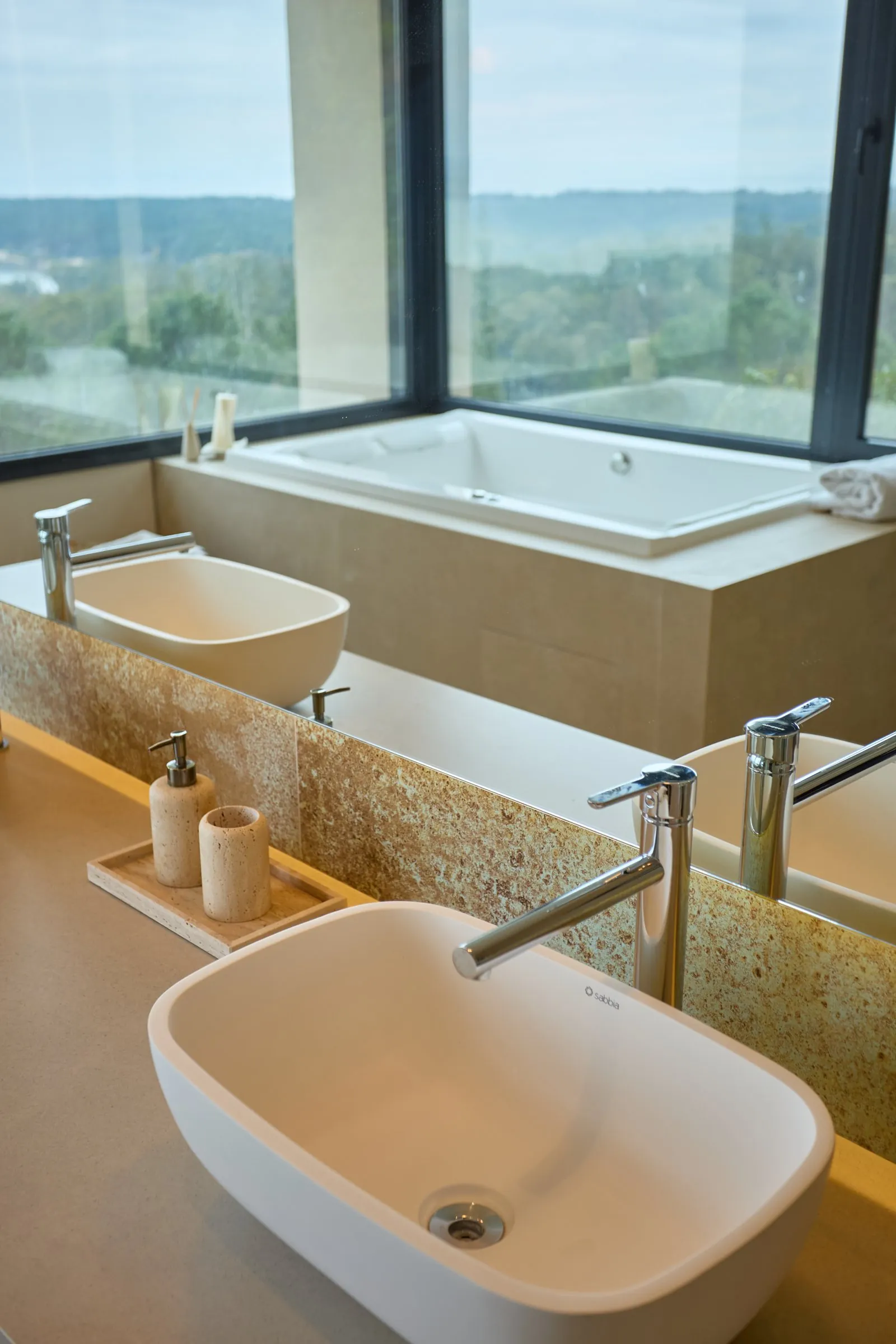 Baño con vanitory de madera, espejo redondo y ducha de vidrio