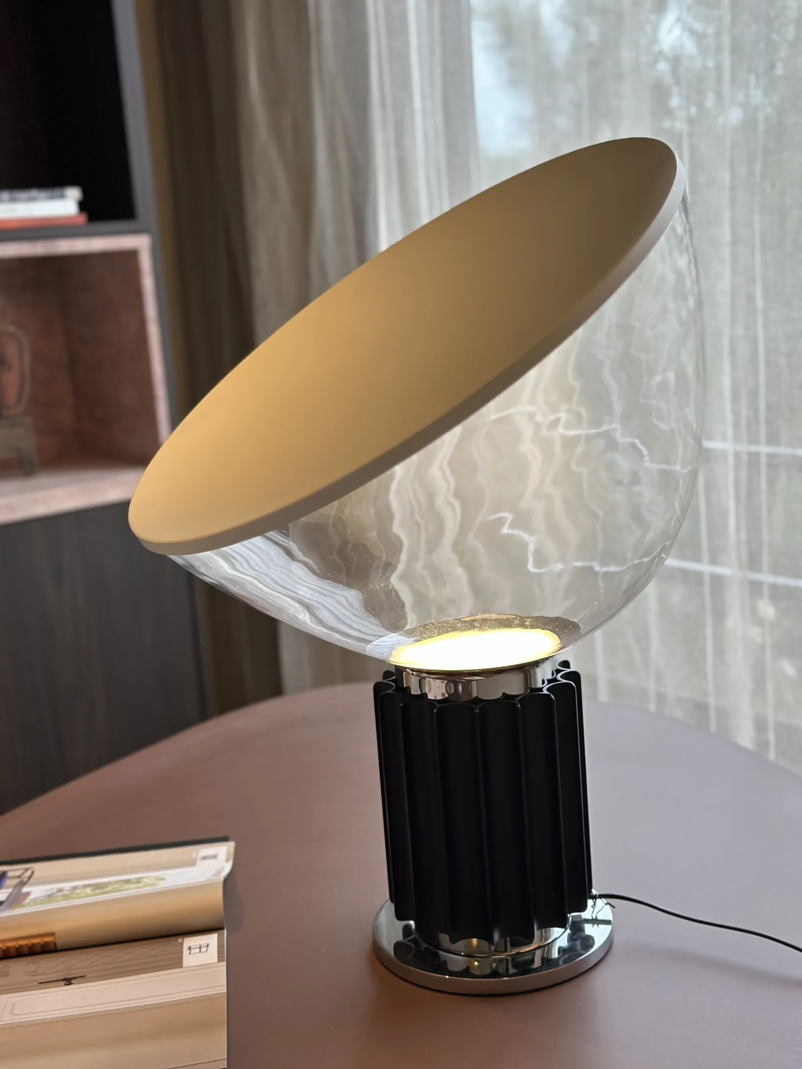 Lámpara de mesa encendida, con pantalla clara y base de vidrio
